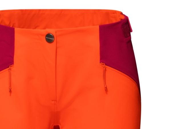Close-up of Mammut bright orange mountaineering pants with a purple waistband and button closure.