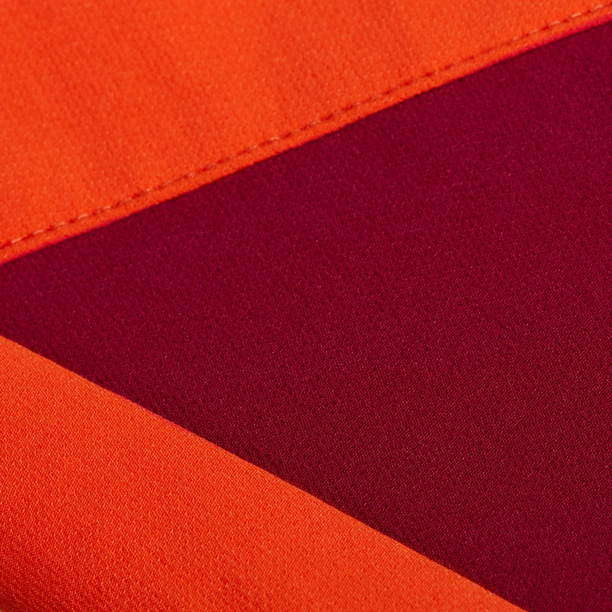 Close-up of Mammut orange and maroon outdoor gear fabric with a diagonal seam.